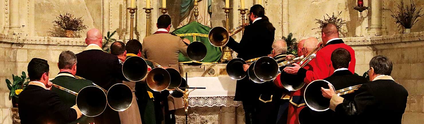 Photo d'un groupe de musiciens jouant de la trompe de chasse dans une église