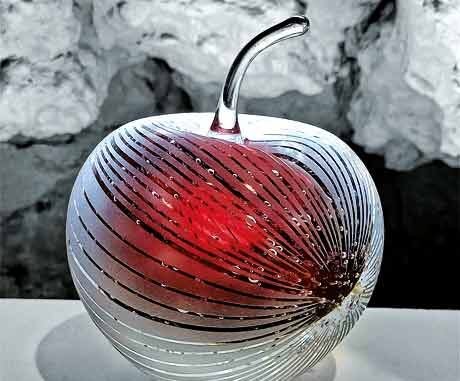 photo d'une pomme rouge en verre soufflé posée sur une table