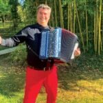 photo d'un accordéonniste devant une bambouseraie