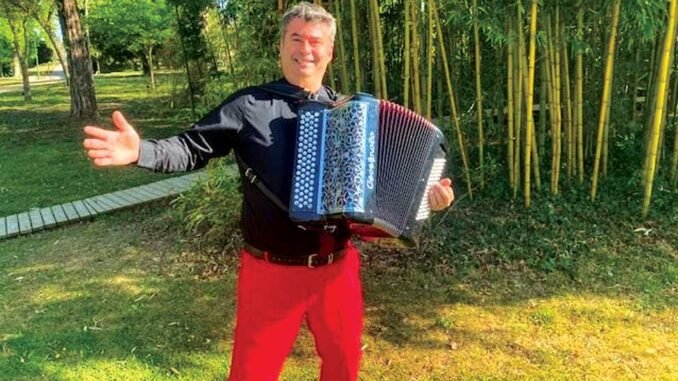 photo d'un accordéonniste devant une bambouseraie